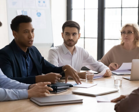 Focused Mixed Race Business People Listening To African American Colleague.